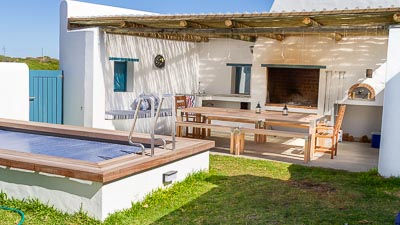 covered braai area with long table and pizza oven